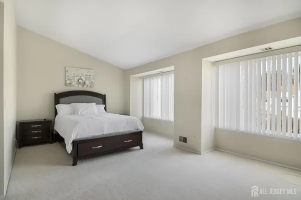 a spacious bedroom with a bed and a window