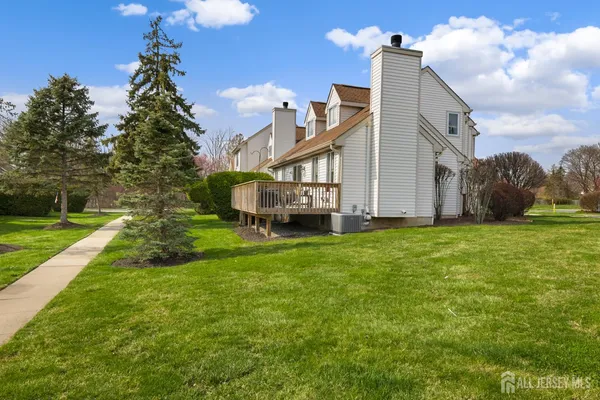 a view of a house with a big yard and large trees