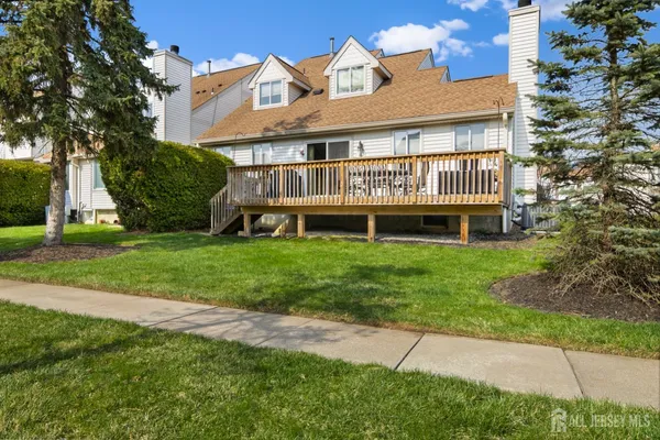 a front view of a house with a yard and potted plants