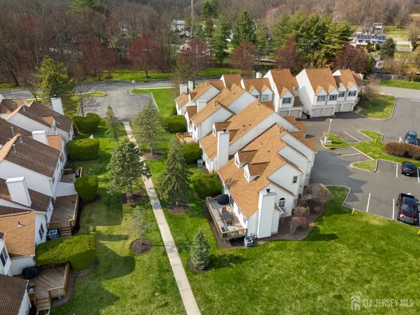 an aerial view of residential houses with outdoor space and parking