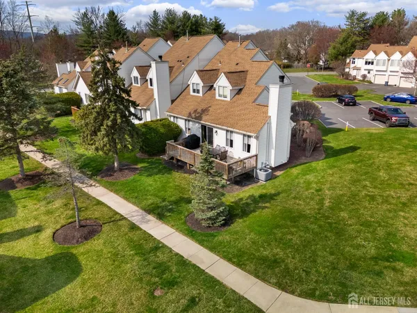 an aerial view of residential houses with outdoor space and trees