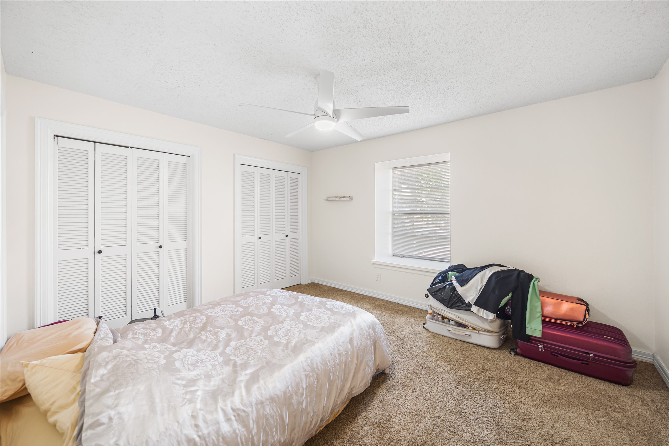 8233 Kingsbrook Road, Unit 233 Houston, TX 77024 - Photo 17 of 24 a bedroom with a bed and a chandelier