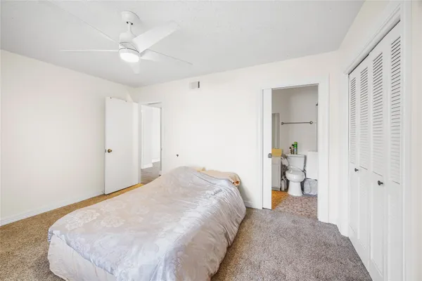 a spacious bedroom with a bed and cabinets