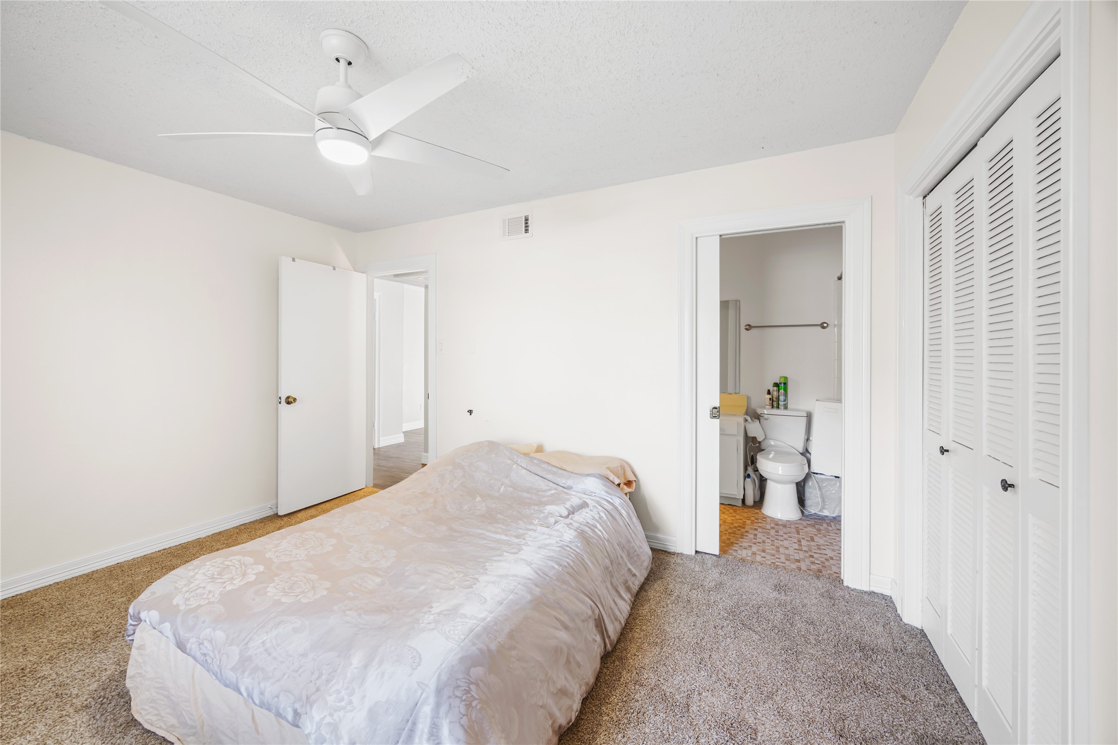 8233 Kingsbrook Road, Unit 233 Houston, TX 77024 - Photo 18 of 24 a bedroom with a bed and a chandelier