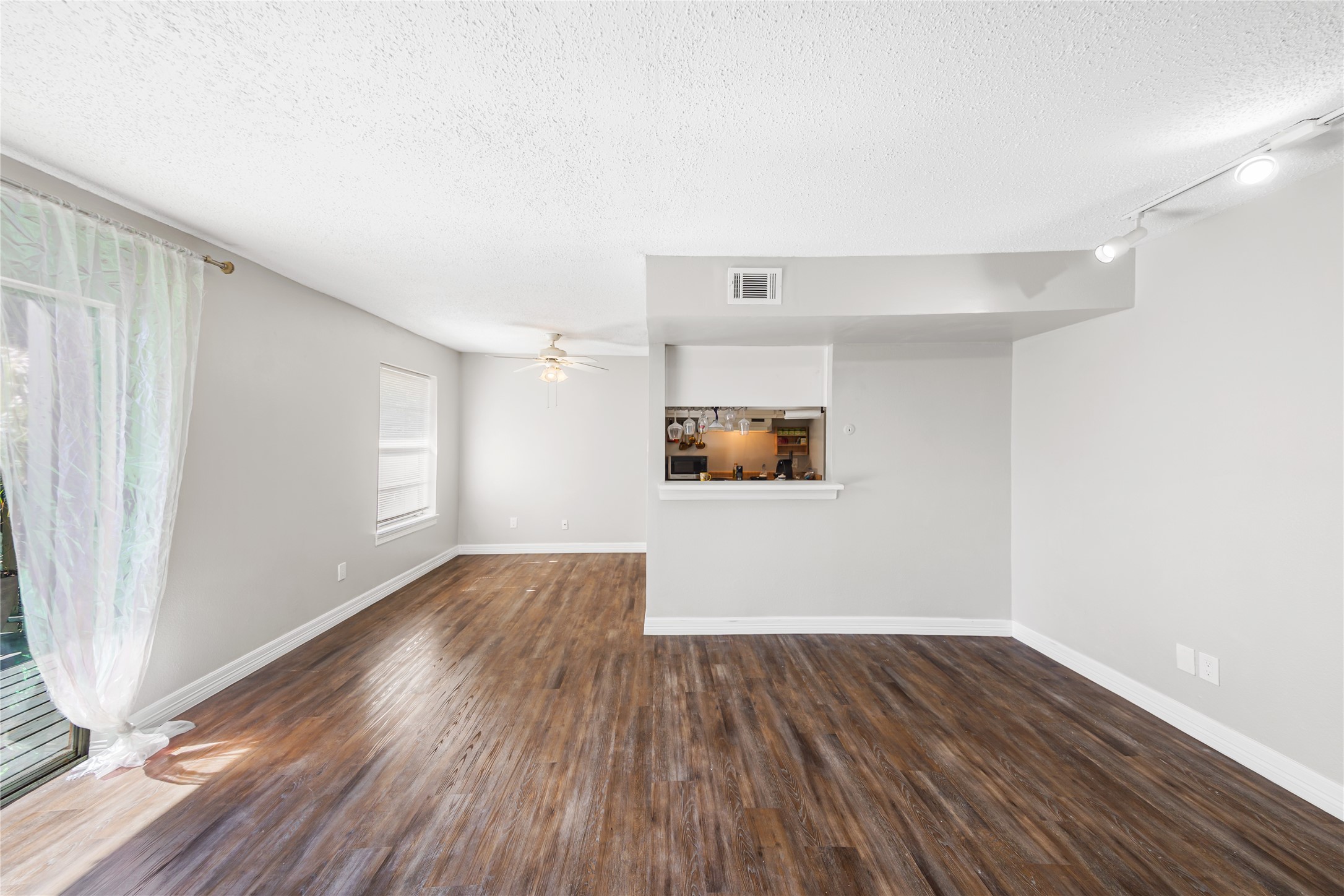 8233 Kingsbrook Road, Unit 233 Houston, TX 77024 - Photo 6 of 24 an empty room with wooden floor and windows