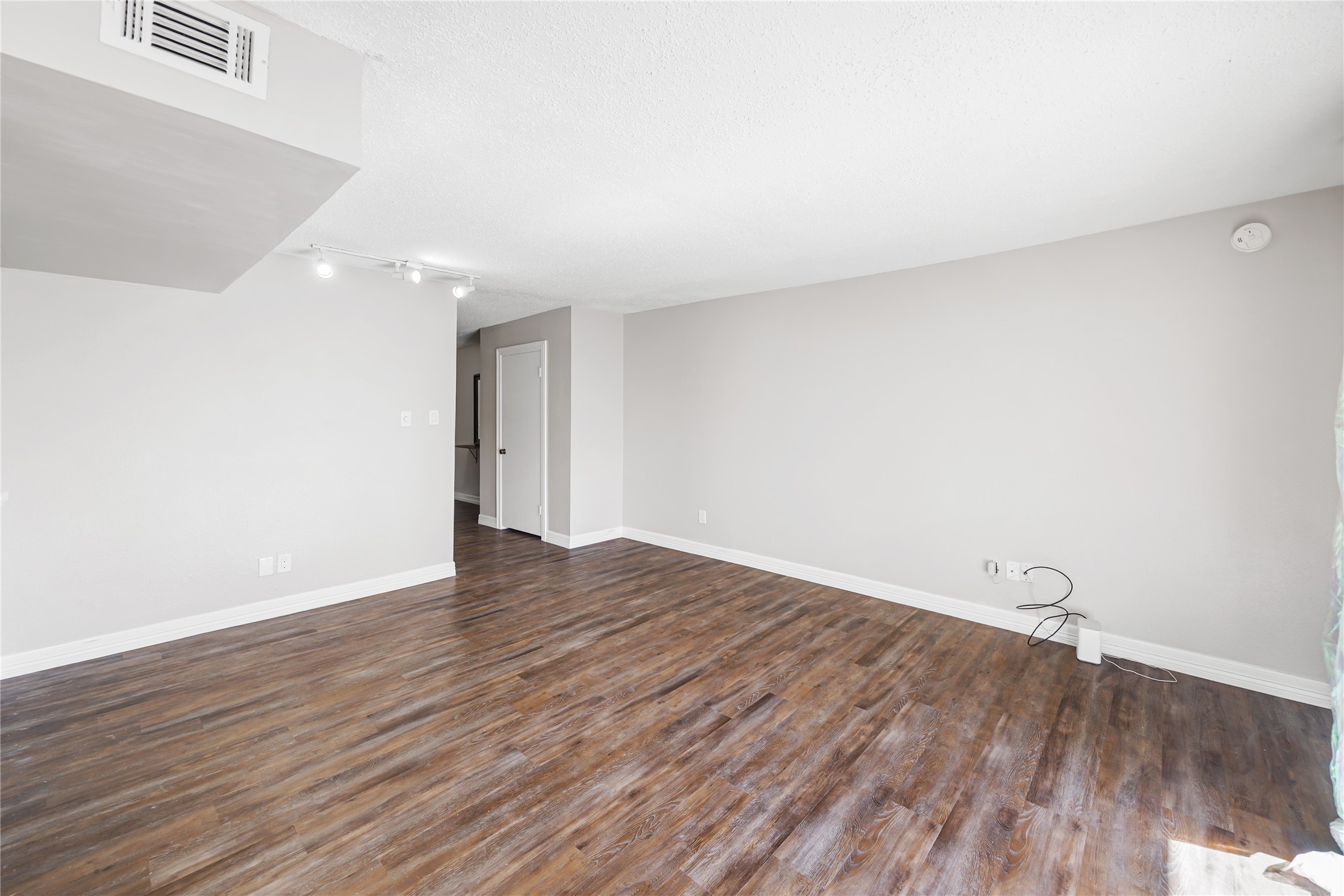 8233 Kingsbrook Road, Unit 233 Houston, TX 77024 - Photo 8 of 24 a view of an empty room with wooden floor and a window