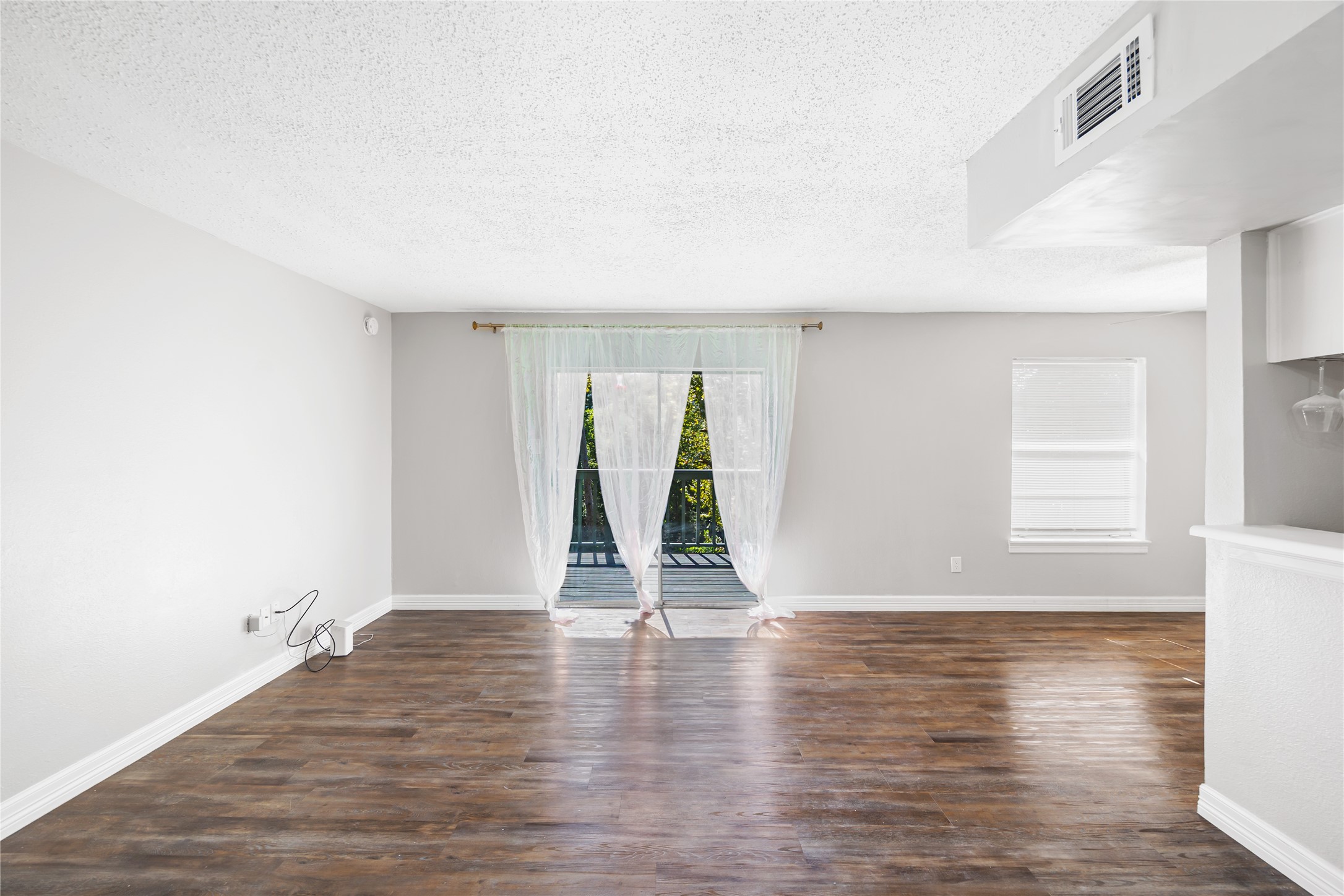 8233 Kingsbrook Road, Unit 233 Houston, TX 77024 - Photo 9 of 24 a view of an empty room with wooden floor and a window
