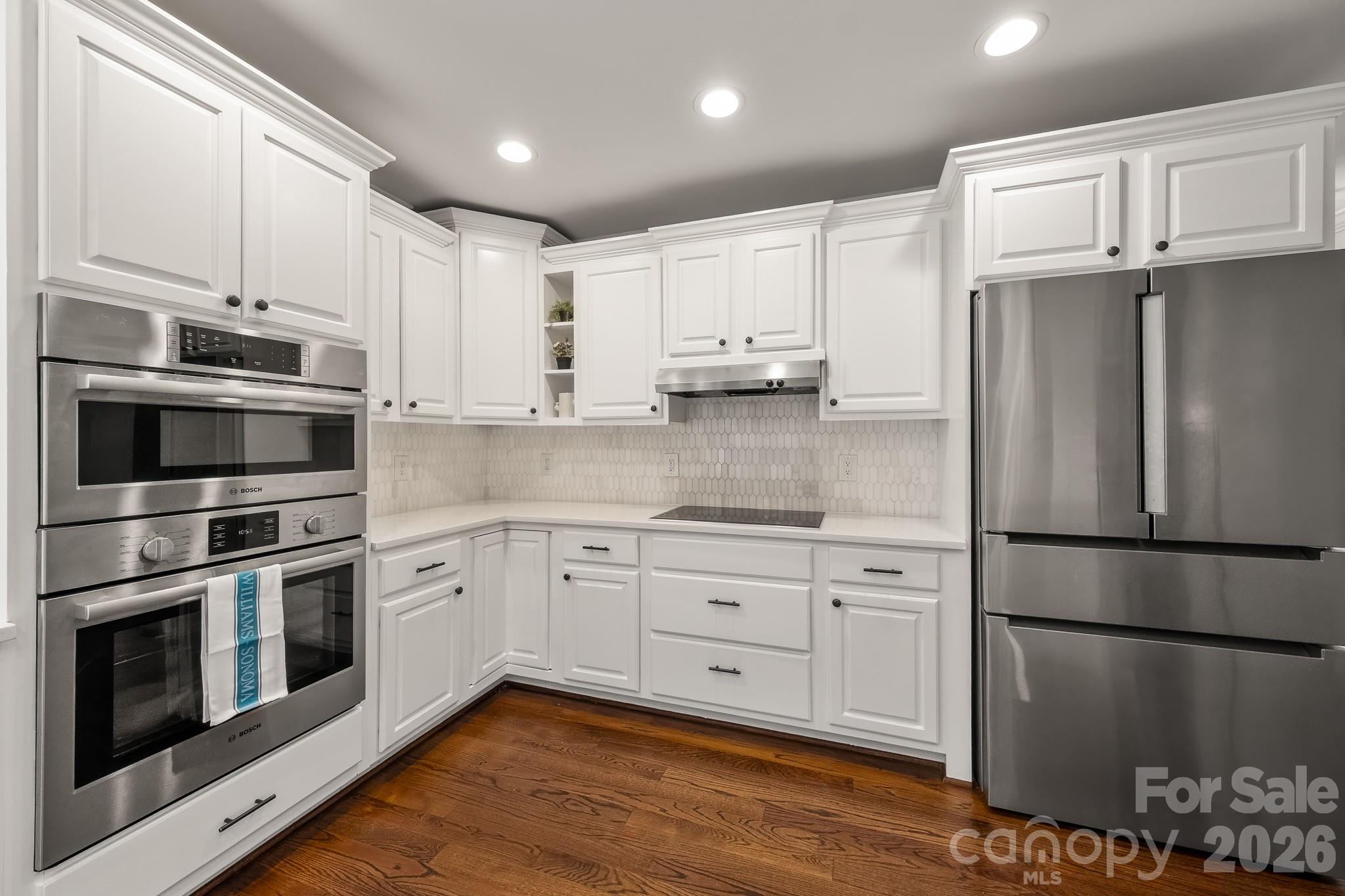 1121 South Wendover Road Charlotte, NC 28211 - Photo 18 of 48 a kitchen with cabinets stainless steel appliances and wooden floor