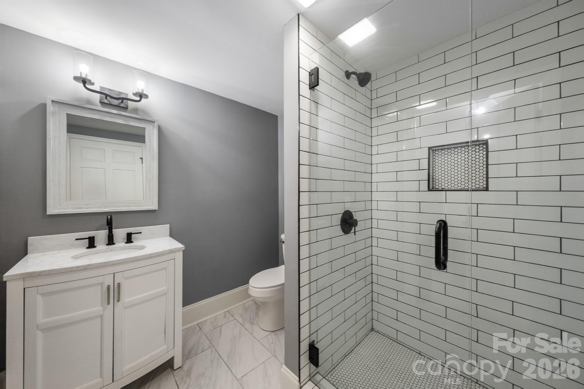 1121 South Wendover Road Charlotte, NC 28211 - Photo 34 of 48 a bathroom with a toilet sink and mirror