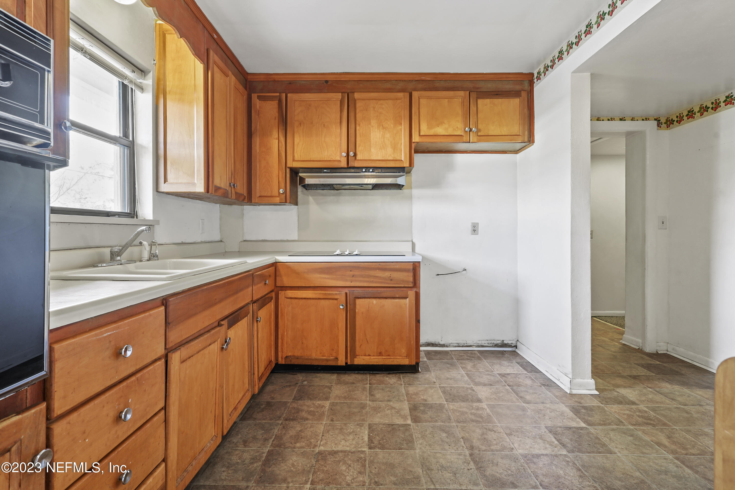 3751 Bess Road Jacksonville, FL 32277 - Photo 17 of 38 a kitchen with granite countertop a sink window and cabinets
