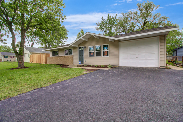 309 Audubon Road Streamwood, IL 60107 - Photo 1 of 25 a front view of a house with a garden and yard