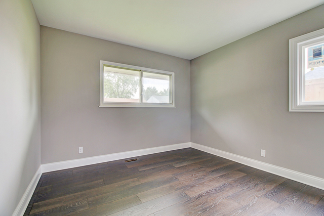309 Audubon Road Streamwood, IL 60107 - Photo 18 of 25 an empty room with wooden floor and windows