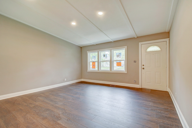 309 Audubon Road Streamwood, IL 60107 - Photo 5 of 25 an empty room with wooden floor and windows