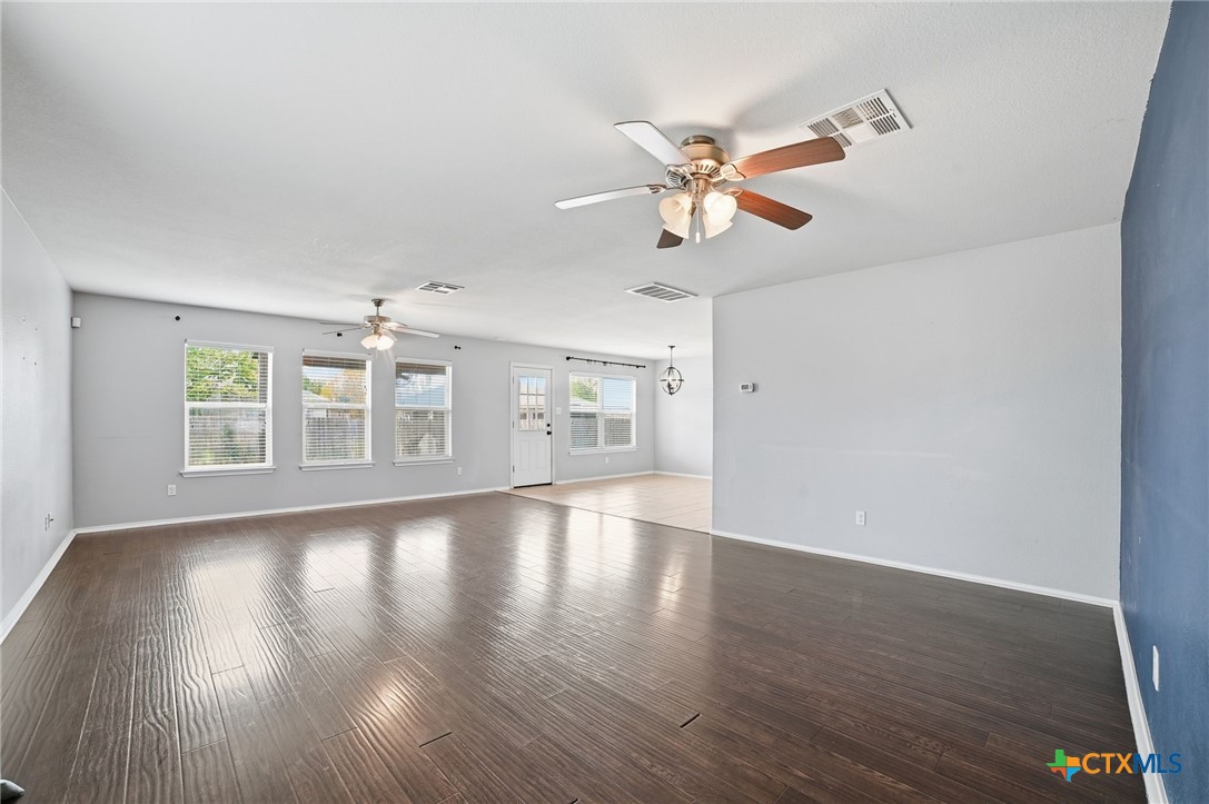 316 Housefinch Loop Leander, TX 78641 - Photo 5 of 37 Large downstairs living room with wood laminate flooring and ceiling fan.