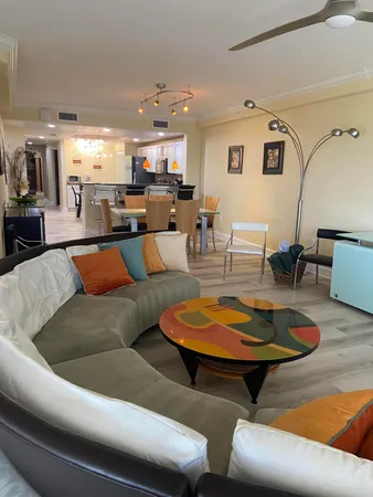 a living room with furniture and kitchen view