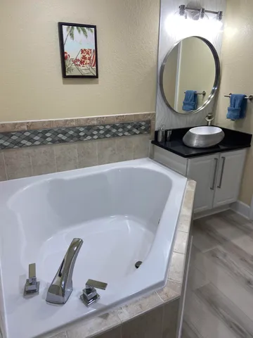 a bathroom with a tub and a mirror