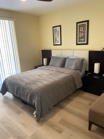 a bedroom with a bed and painting on the wall