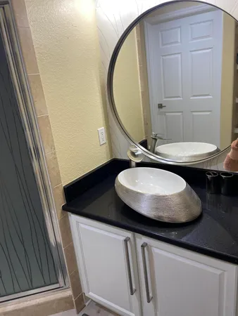 a bathroom with a granite countertop sink and a mirror