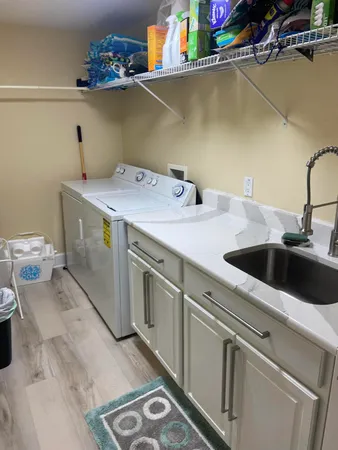 a utility room with sink dryer and washer