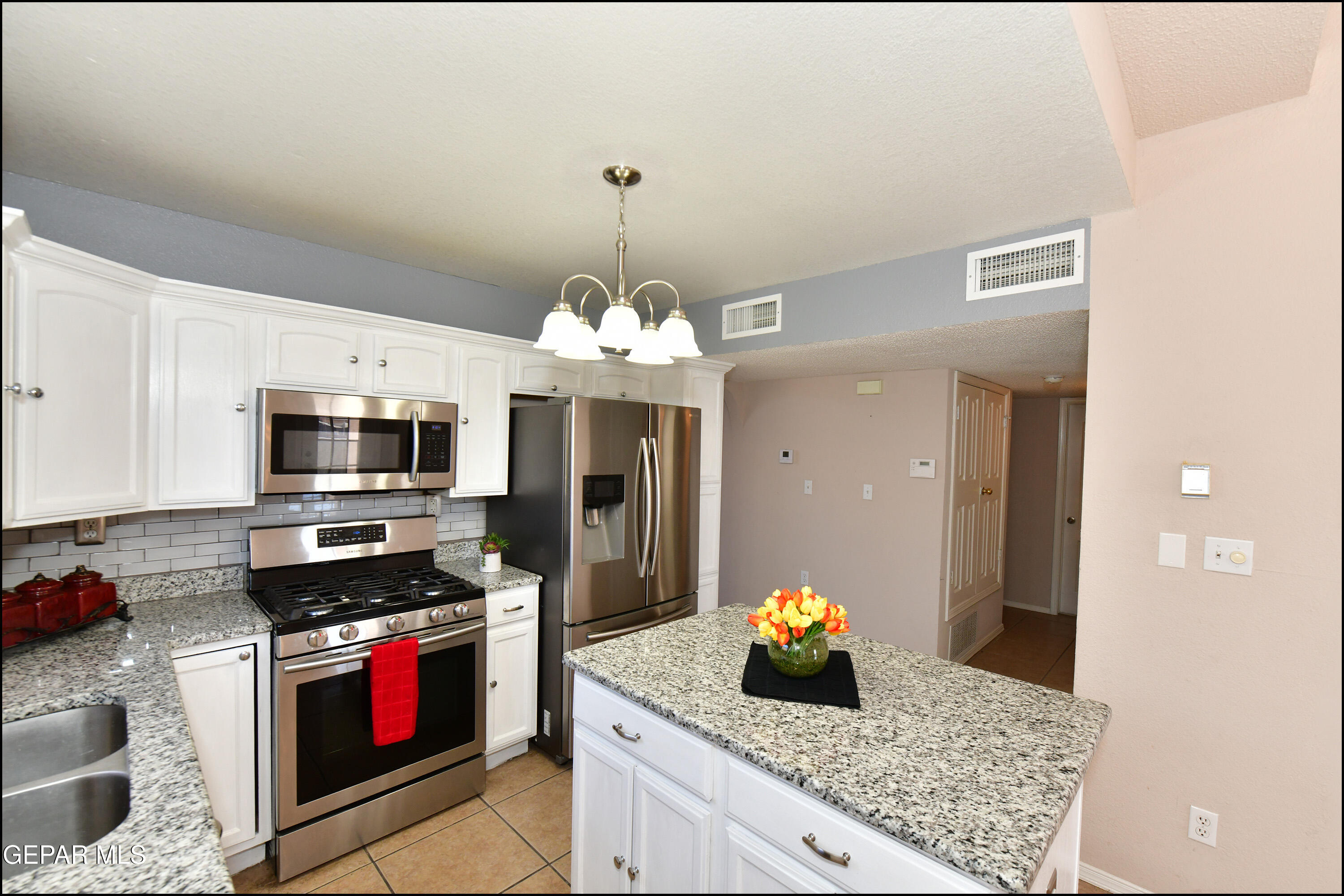 12232 Tierra Rosa Way El Paso, TX 79938 - Photo 9 of 34 a kitchen with stainless steel appliances granite countertop a stove and a microwave