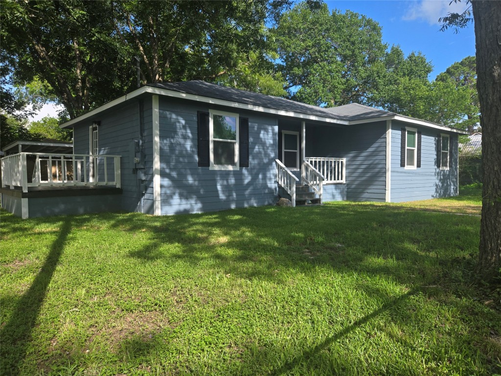 View of front of property featuring a front lawn and a wooden​​‌​​​​‌​​‌‌​‌‌​​‌​​​​‌​​​‌‌​‌‌‌ deck