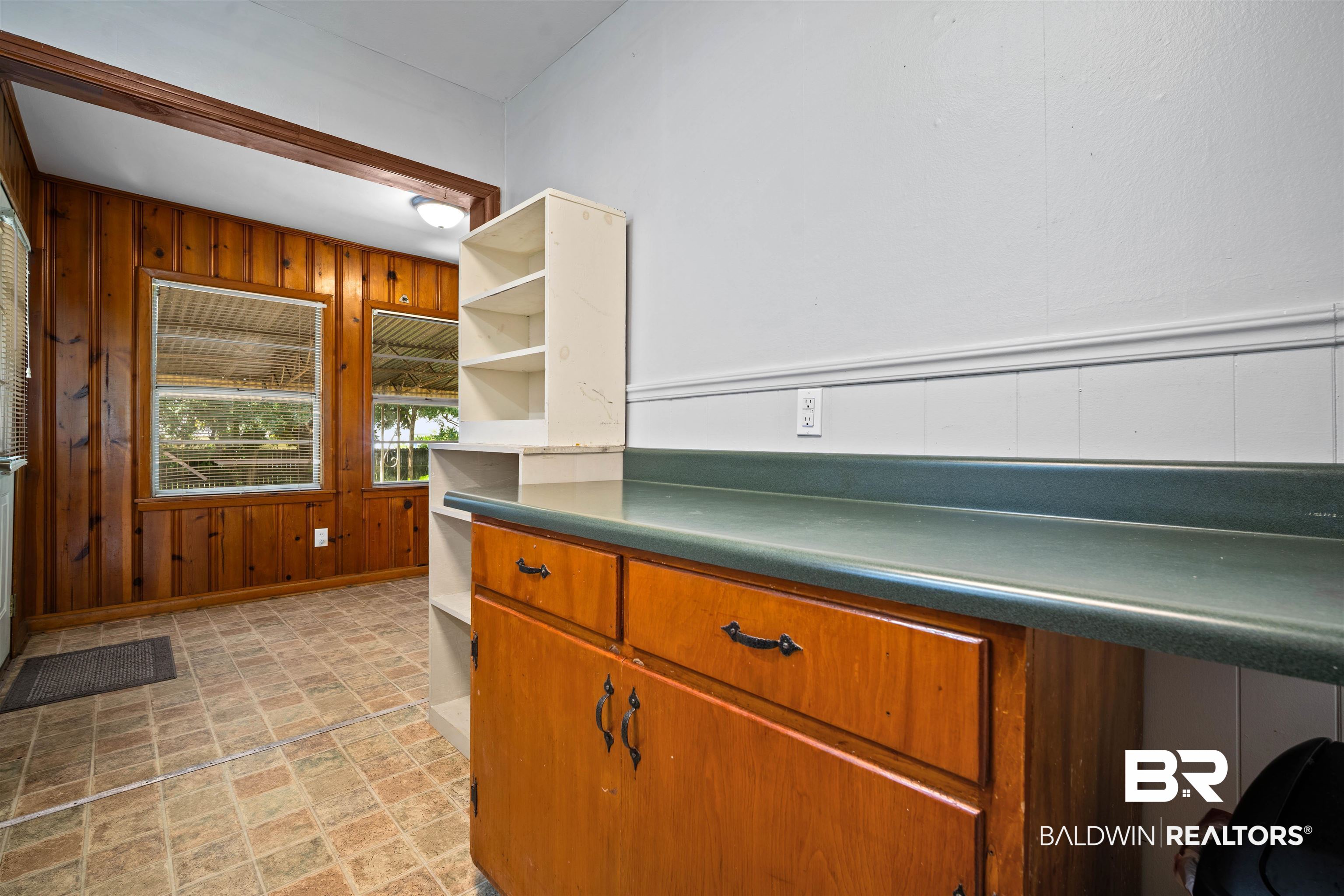 9 Elizabeth Avenue Mobile, AL 36611 - Photo 9 of 19 Kitchen with open shelves, wooden walls, light stone finish flooring, and dark countertops