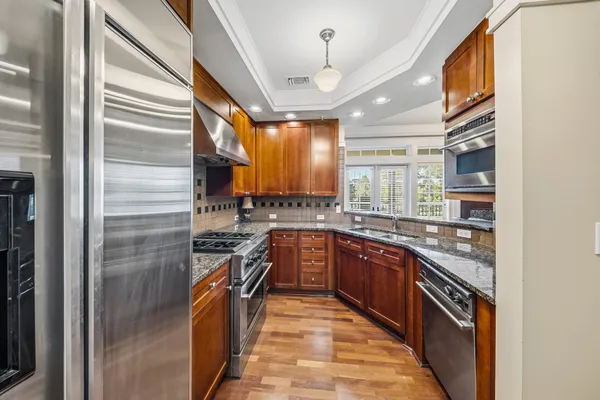 a kitchen with stainless steel appliances granite countertop a sink stove and refrigerator
