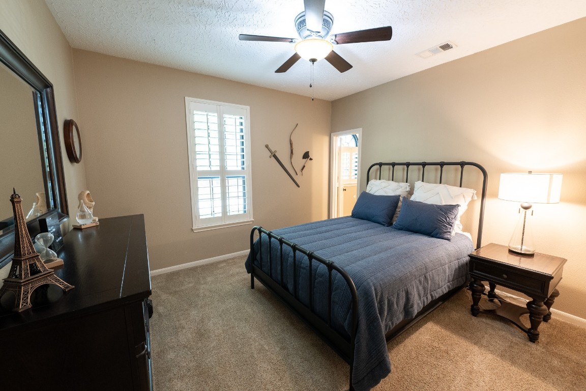 6 Red Sable Point The Woodlands, TX 77380 - Photo 26 of 50 a bedroom with a bed flat screen tv and windows
