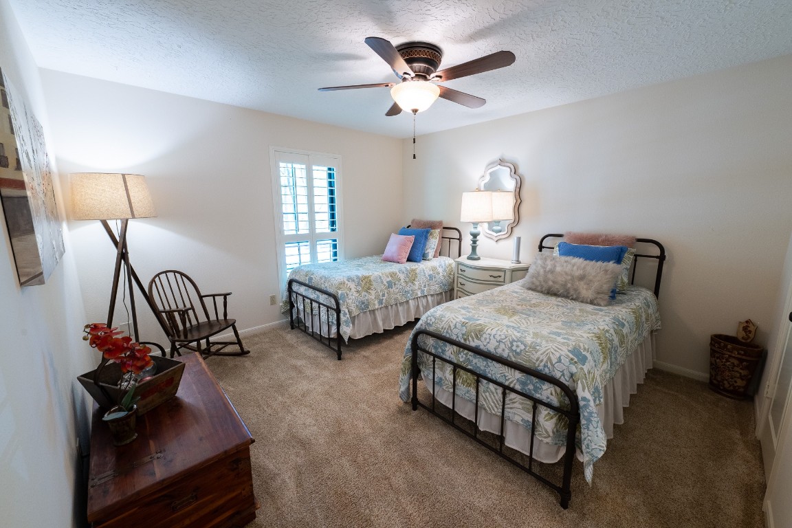 6 Red Sable Point The Woodlands, TX 77380 - Photo 31 of 50 a bedroom with two beds and a chandelier