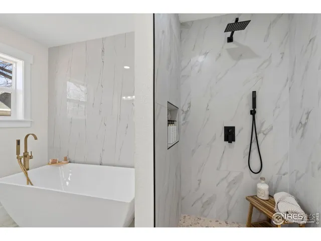 a bathroom with a white bath tub sitting next to shower