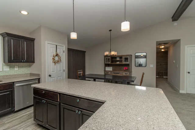 a kitchen with kitchen island a sink stainless steel appliances and cabinets