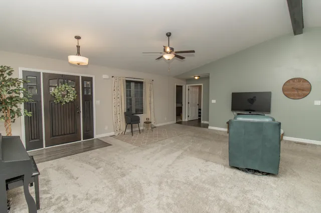 a living room with furniture a flat screen tv and a window