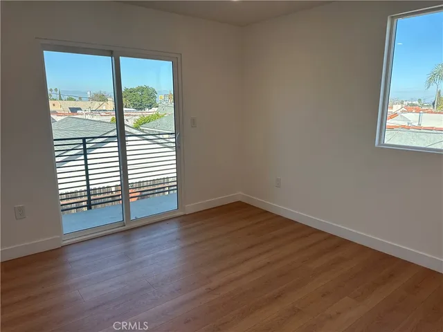 a view of a room with wooden floor and a window