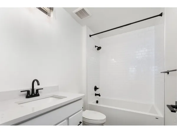 a bathroom with a sink a toilet a shower and a mirror