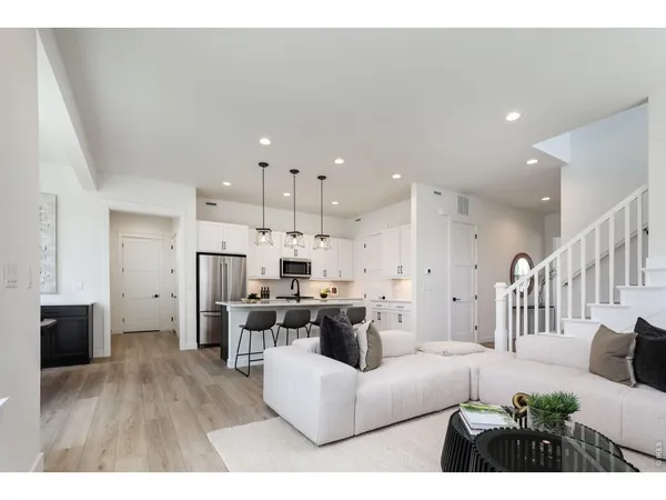a living room with furniture and a dining table with kitchen view