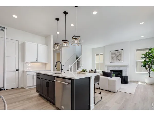 a kitchen with kitchen island granite countertop a sink cabinets and wooden floor