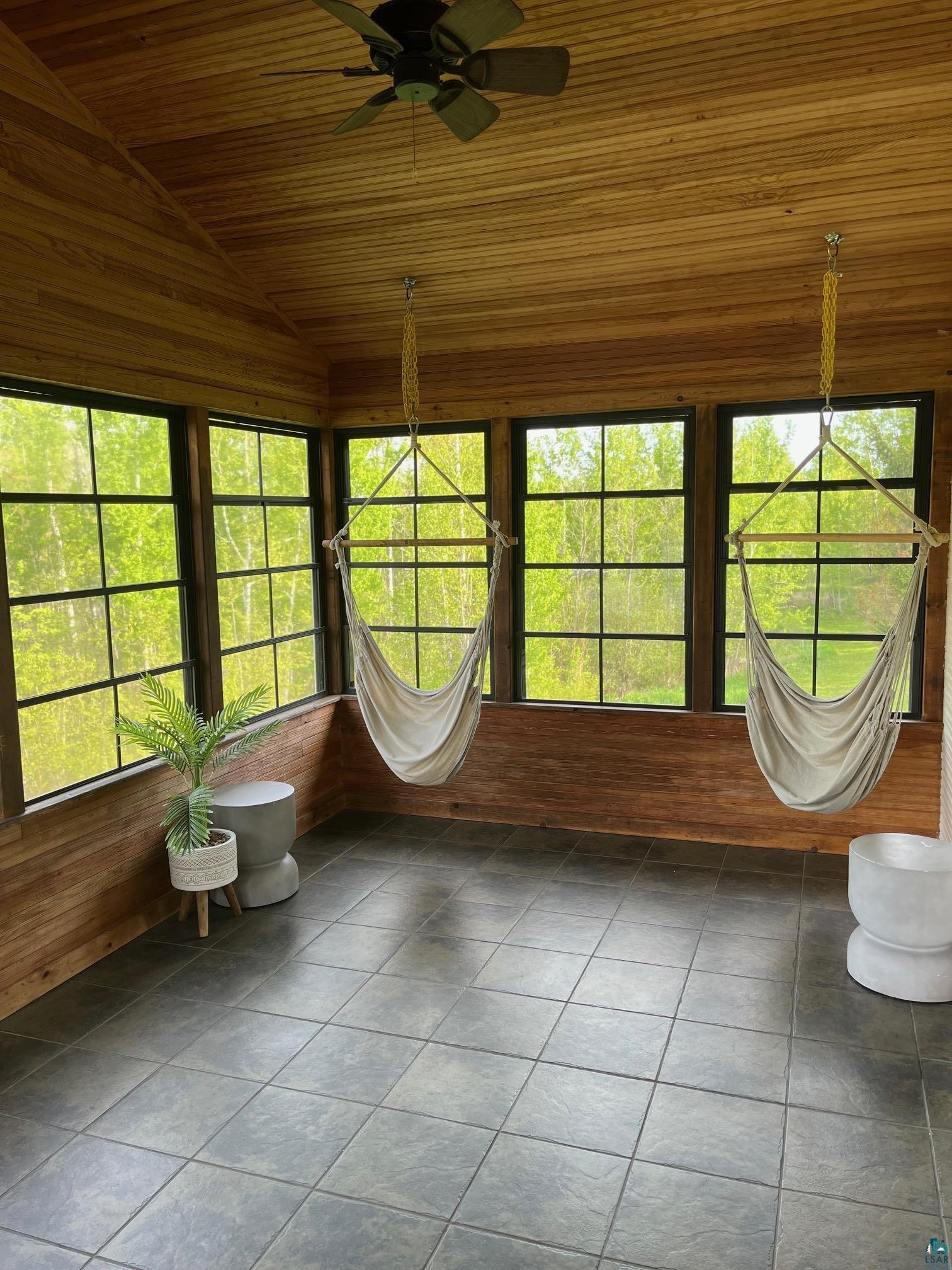 3325 Strand Road Duluth, MN 55803 - Photo 25 of 25 Expansive screened-in porch featuring a wood-panel ceiling, dark tile flooring, and wood-paneled wainscoting