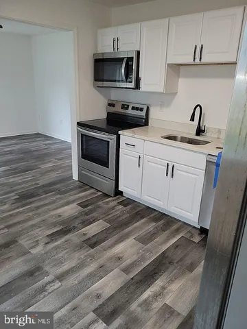 a kitchen with stainless steel appliances granite countertop a sink a stove and microwave