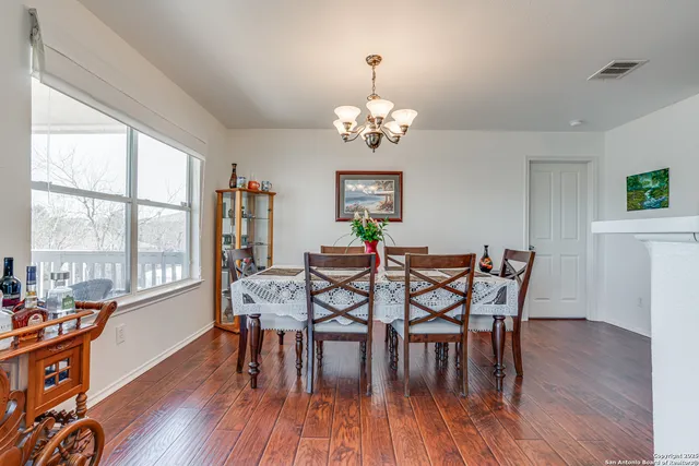 a view of a dining room with furniture a chandelier and wooden floor
