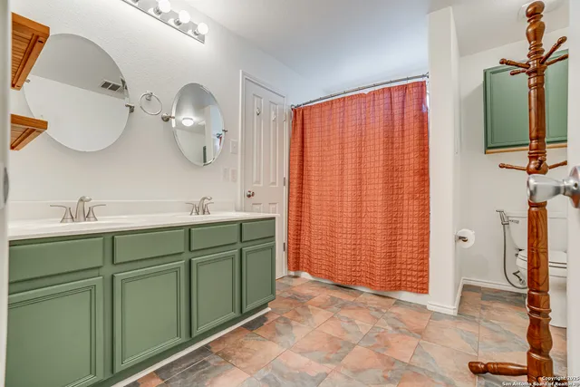 a spacious bathroom with a double vanity sink mirror and shower