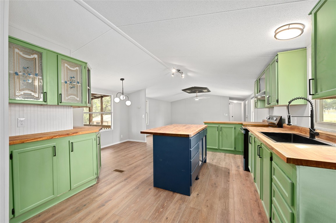 20123 McShepherd Road Georgetown, TX 78626 - Photo 5 of 27 a kitchen with kitchen island a sink wooden floor and a view of living room