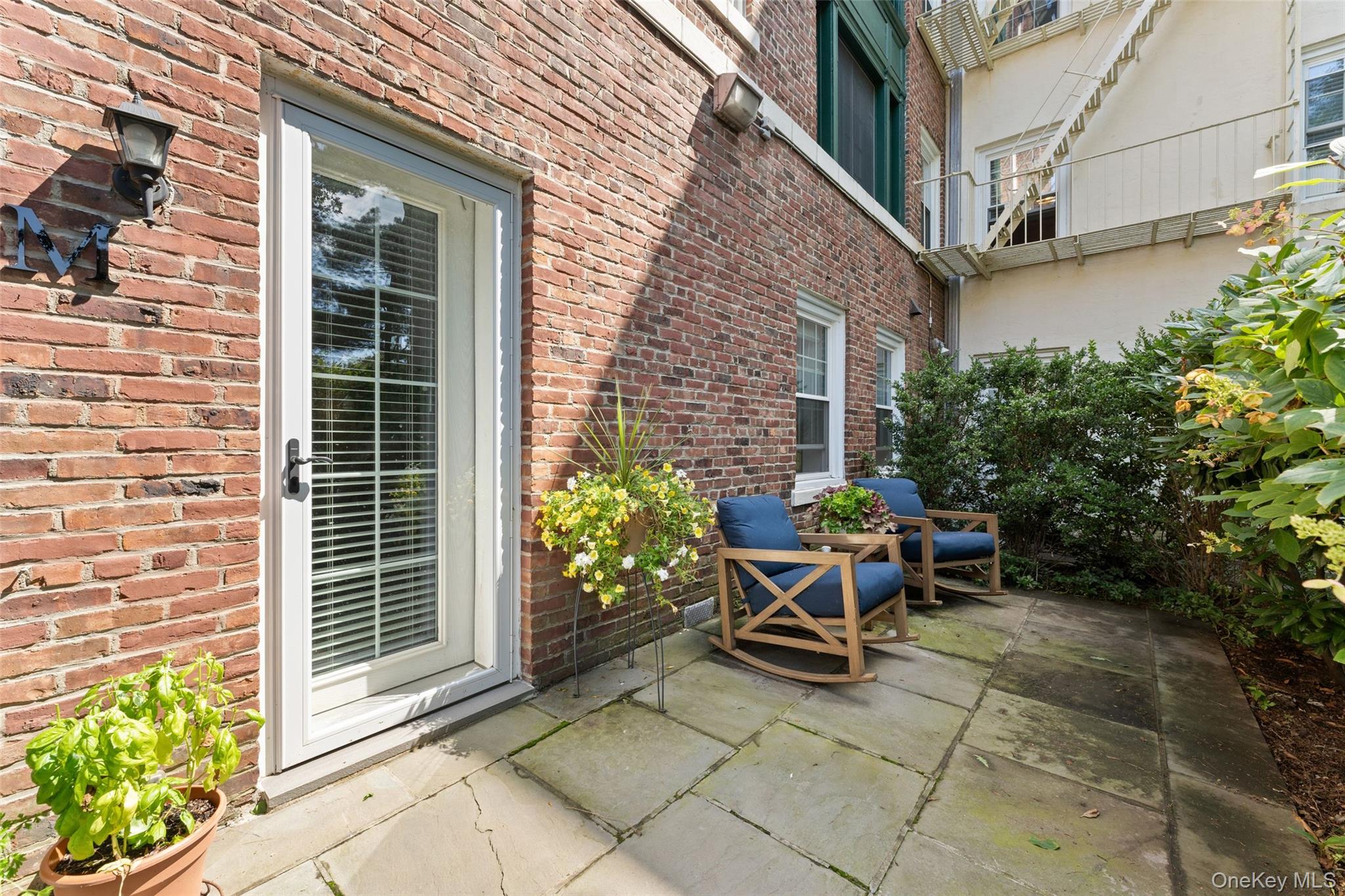 a view of backyard with outdoor seating and a potted plant
