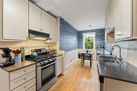 a kitchen with stainless steel appliances granite countertop a sink stove and cabinets