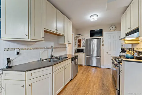 a bedroom with a bed and a flat tv screen on dresser