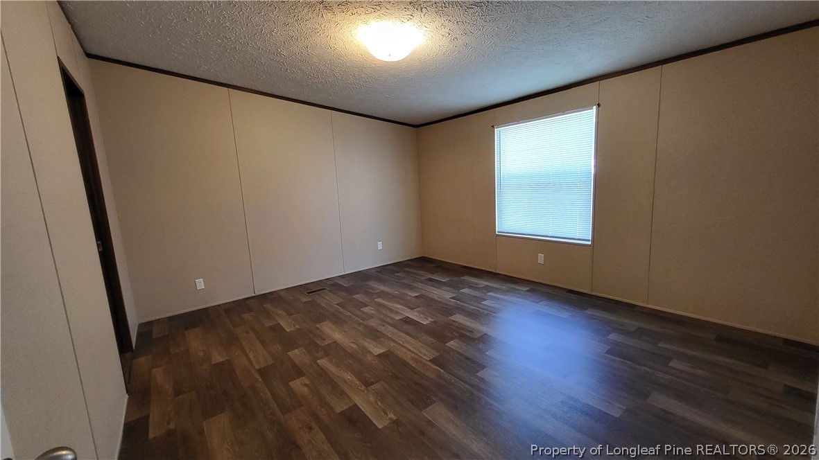 115 Burns Road Lumberton, NC 28358 - Photo 7 of 11 an empty room with wooden floor and windows