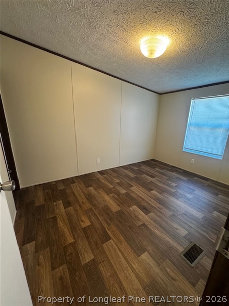 115 Burns Road Lumberton, NC 28358 - Photo 8 of 11 en empty room with wooden floor and windows