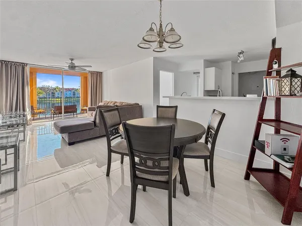 a dining room with furniture a chandelier and wooden floor