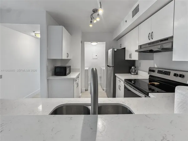 a kitchen with stainless steel appliances a stove a sink and a refrigerator