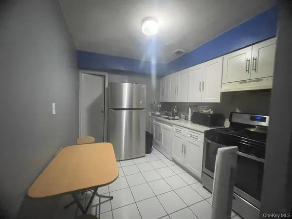 a kitchen with a refrigerator a stove a sink and cabinets
