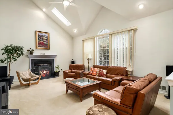 a living room with furniture a fireplace and a large window